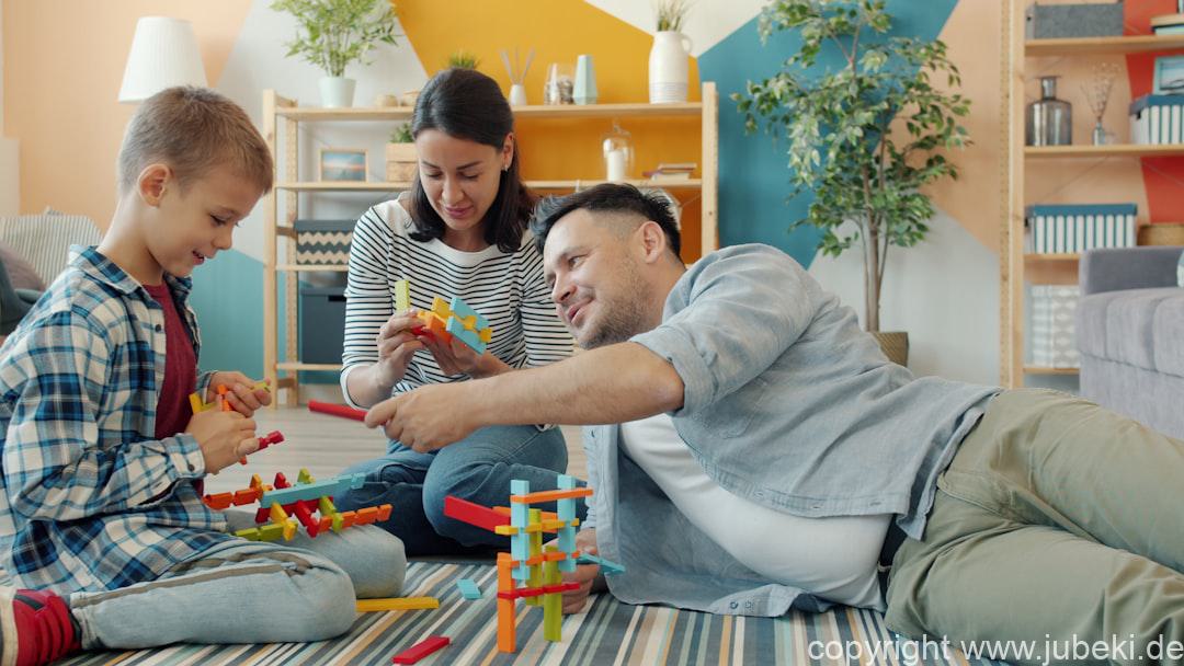 Familie spielt gemeinsam mit Kindern ein Gesellschaftsspiel